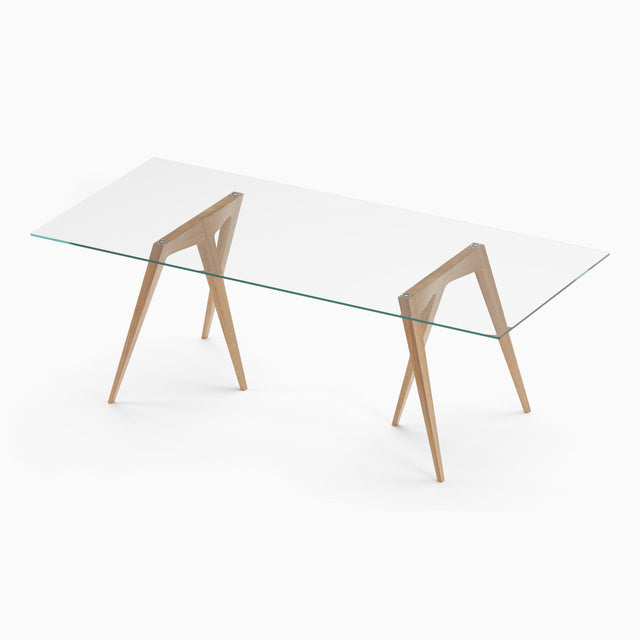 A pair of solid Oak Flex Trestle Table Legs are paired with a glass tabletop to form a dining table. This combination can also be used as a trestle desk.