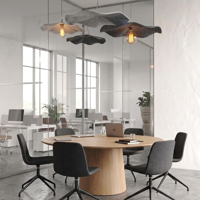 Two Flutter acoustic suspension panels and 2 Flutter acoustic pendant light hang over a table in a meeting room of a modern workplace.