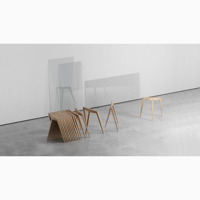 Multiple oak Flex trestle table legs nested together for compact storage.