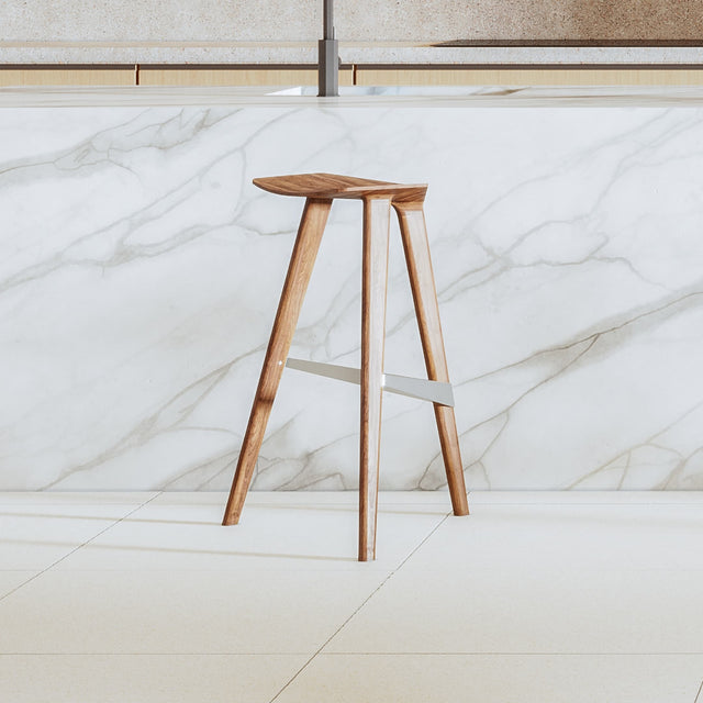 The back side of a Delta counter stool, made in Walnut. The angle shows how the stool’s streamlined form and forward-leaning stance afford it a dynamic aesthetic.