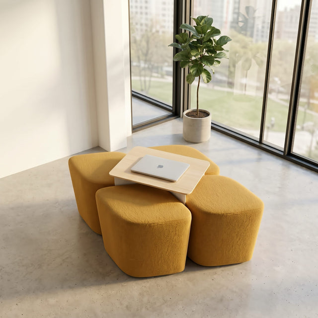 The Rhombic seating system with its 4 yellow poufs stowed away under its table, leaving the space neat and tidy and ready for use.