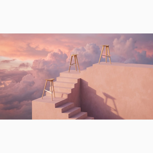 Three solid oak Delta bar stools on a staircase in an abstract cloud and sunset setting.