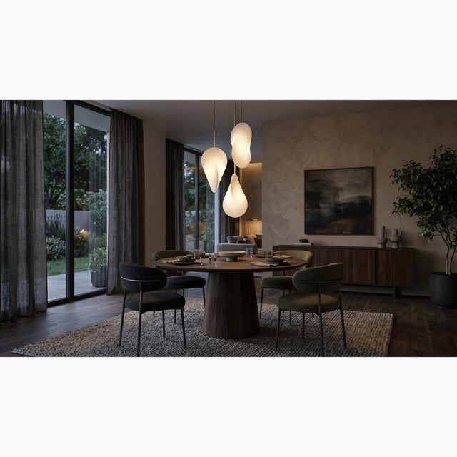 Three Oh Lloyd! pendant lights create a focal point over a round dining table in a modern living space. The lights are staggered at different height and orientated at different angles, showing off Oh Lloyd's unique form, whilst emitting a soft warm glow that illuminates the room.