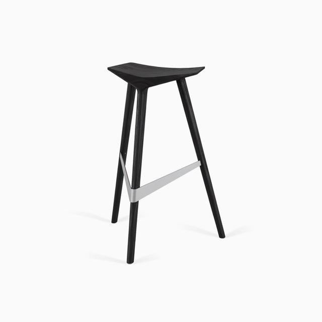 A Delta bar stool in black stained Ash, with a brushed stainless steel footrest.