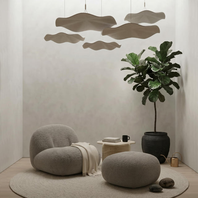 A series of Flutter acoustic suspension panels hang over a lounge chair in a zen-inspired quiet room.
