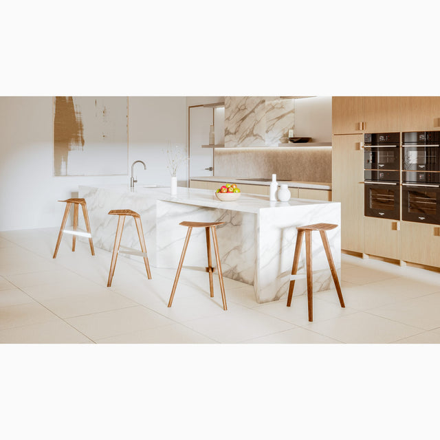 Four Delta counter stools, in solid Walnut, surround a kitchen island. Delta’s streamlined design looks beautiful from every angle.