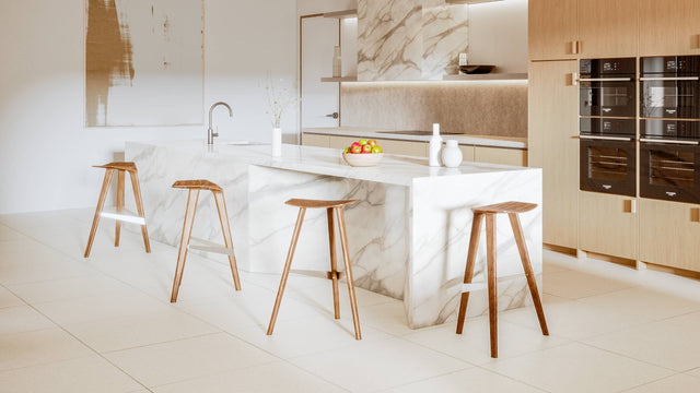 Four Delta counter stools, in solid Walnut, surround a kitchen island. Delta’s streamlined design looks beautiful from every angle.