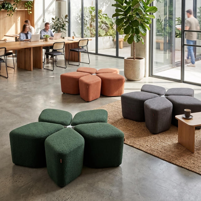 Three Blossom Seating Systems, in different coloured fabrics, scattered across a communal workspace. 