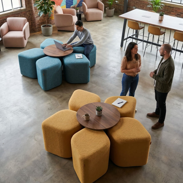 Two vibrant Blossom seating systems bring colour to a trendy, open-plan office breakout space. One setup features yellow poufs and the other blue, with both configurations centred around Walnut tables.
