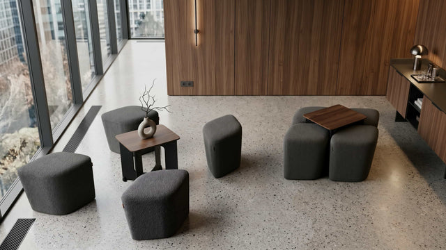 A luxury waiting space in a boutique hotel features two Rhombic seating systems, each with grey poufs and walnut tables.