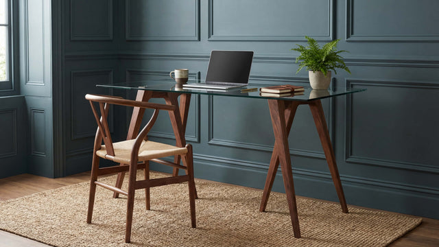 Two Walnut Flex Desk Trestles Legs with a glass tabletop in a home office with heritage green paint and bead wall panelling.