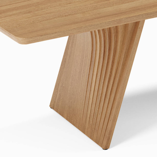 The Veer dining table’s bases are constructed from layers of curved wood, inspired by geological strata formations.