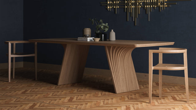 The Veer dining table in solid Oak. Its two monobloc bases are constructed from layers of curved wood.