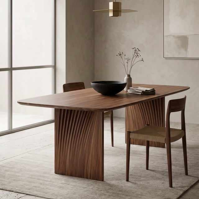 A Sheer dining table in Walnut takes centre stage in a modern, bright dining room with stonewashed walls and minimalist styling.